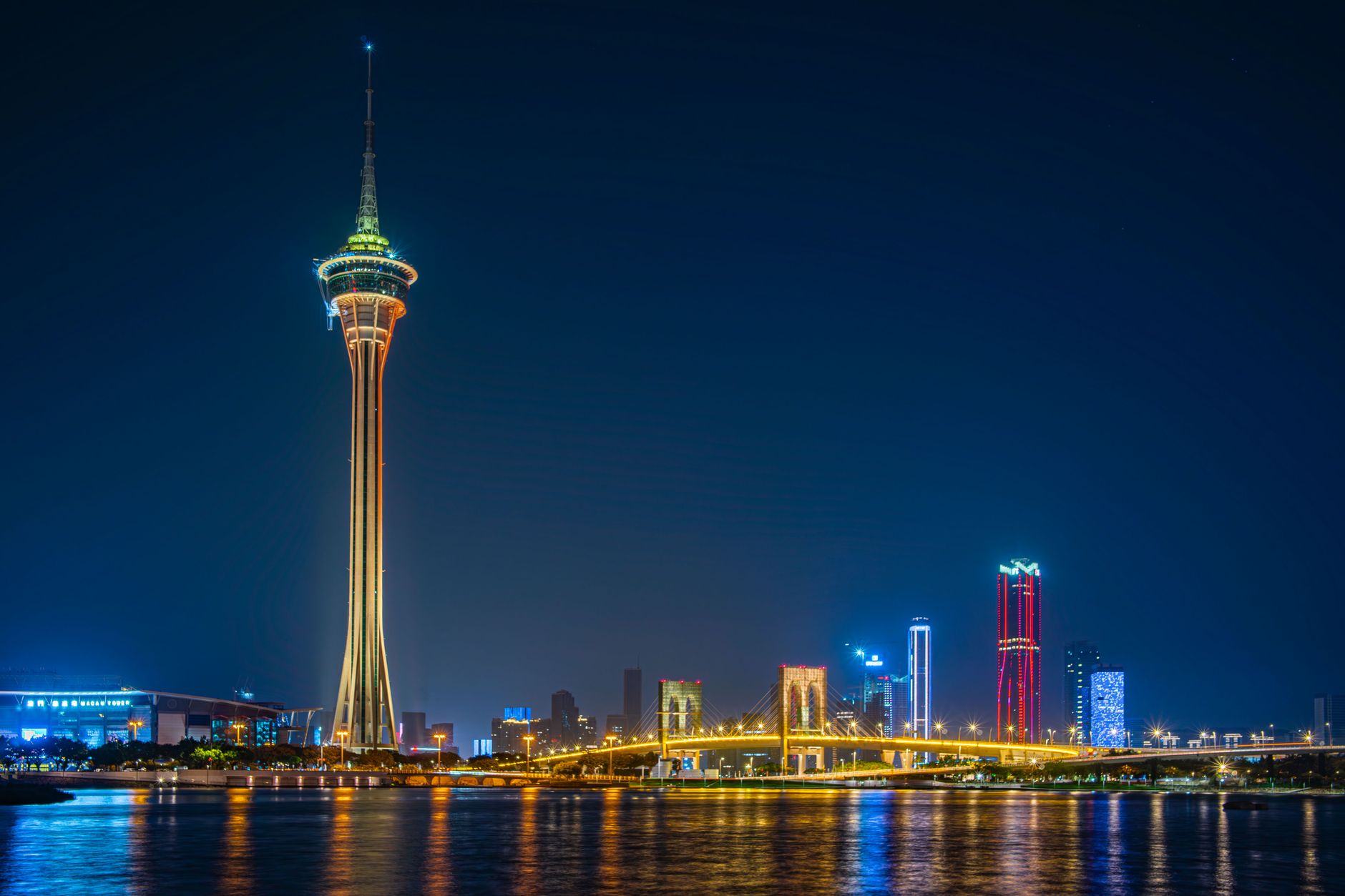 Wieczorny widok na wieżę Macau Tower, most i oświetloną panoramę miasta