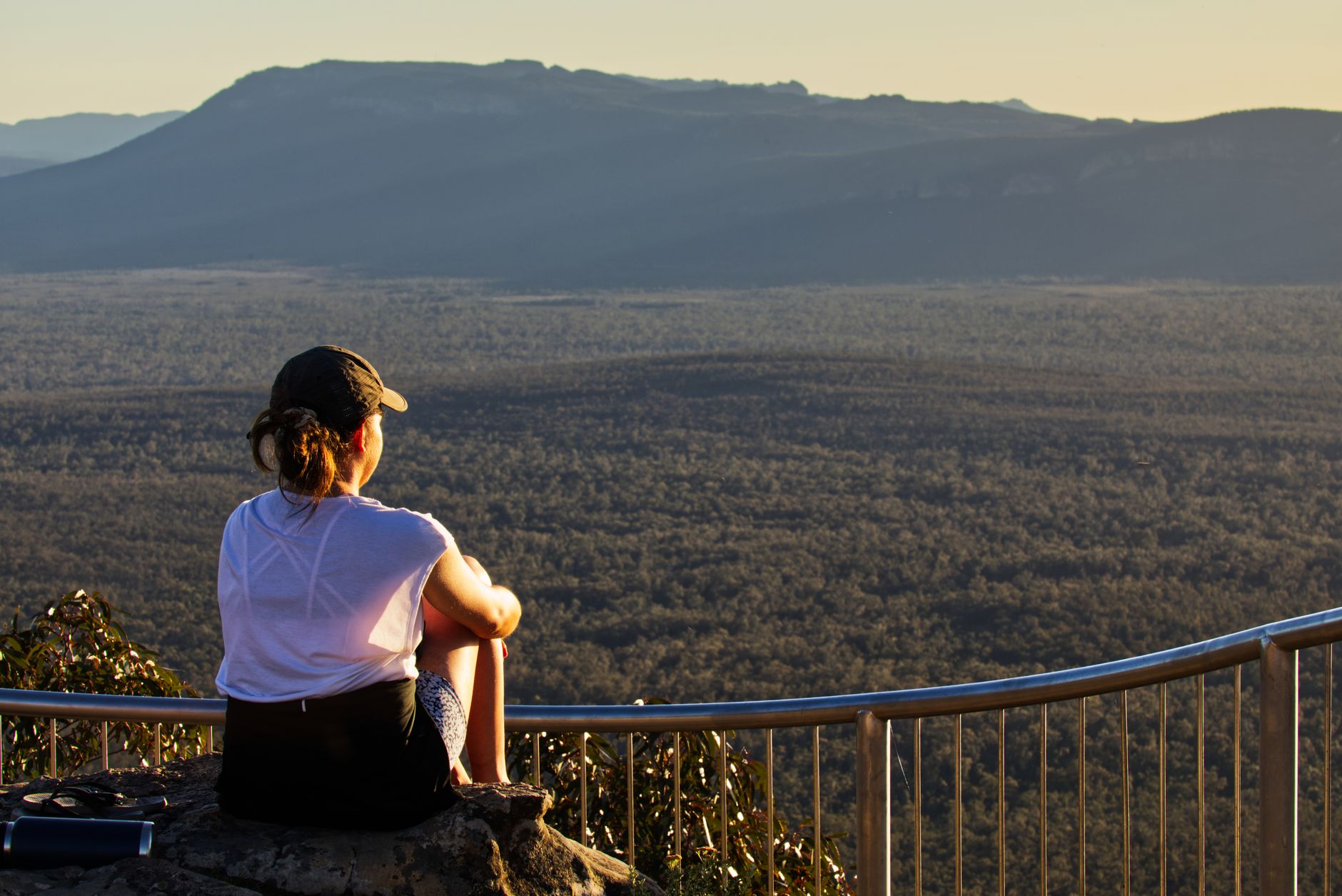 Kobieta na skale podziwia zachód słońca w Górach Grampians w Australii